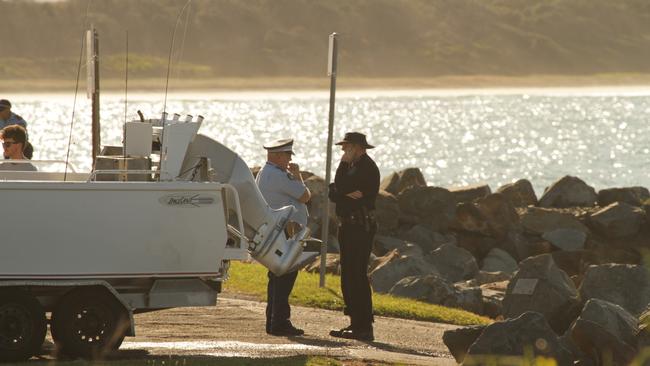 Police at the scene where a fisherman was brought ashore unconscious at Crowdy Head on the mid north coast. Witnesses saw the man fall from his vessel four nautical miles from Diamond Head.