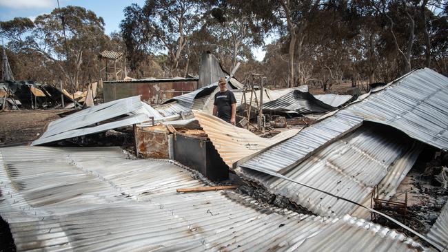 Shane surveys the wreckage of his home, lost in the fire. Picture: Brad Fleet