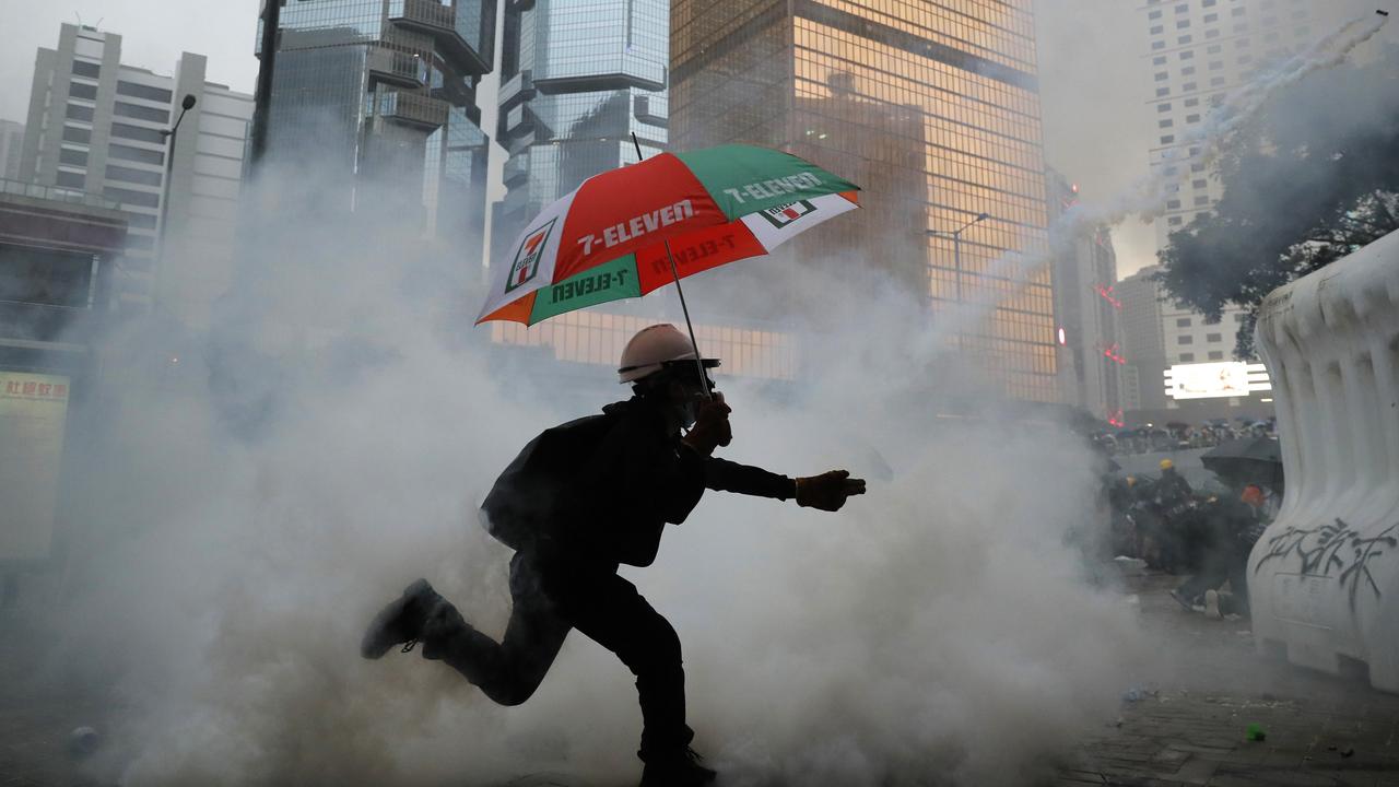 A protester throws back an exploded tear gas shell at police officers in Hong Kong. Picture: AP
