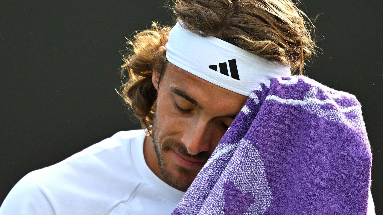 Greece's Stefanos Tsitsipas uses a towel during a break in play against Finland's Emil Ruusuvuori during their men's second round singles tennis match at the Wimbledon Championships on July 4, 2024. (Photo by ANDREJ ISAKOVIC / AFP) / RESTRICTED TO EDITORIAL USE