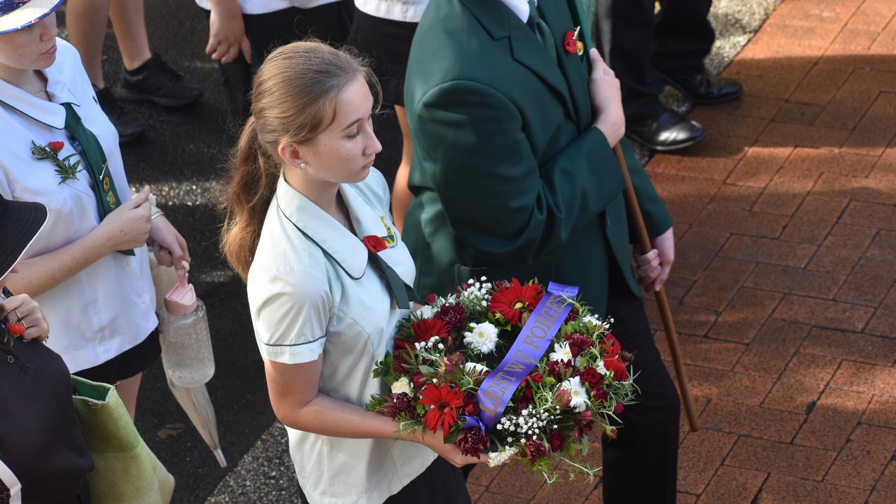 A student carries a wreath in the parade.