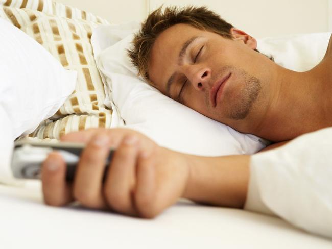 Sleeping Man Holding Cell Phone THINKSTOCK IMAGE