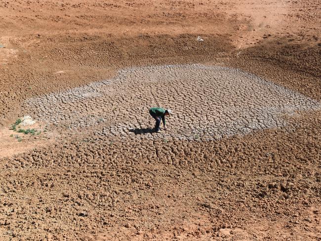 Farmer Lachlan Gall stands at the bottom of one of his empty dams on his property at Langawirra Station north of Broken Hill. Picture: AAP Image/David Mariuz