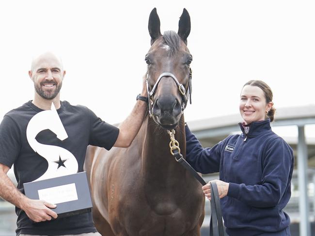 Collingwood Magpies AFL footballer Steele Sidebottom poses with Pride Of Jenni and strapper Sammie Waters ahead of the $4 million Sharp EIT All-Star Mile during a Pride Of Jenni stable media call at Cranbourne Racecourse on March 12, 2024 in Cranbourne, Australia. (Photo by Scott Barbour/Racing Photos via Getty Images)