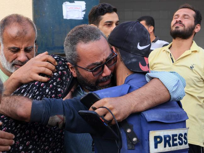 Family and friends of Palestinian cameraman Mohammed Alaloul try to console him after two of his children and his brother were killed in an Israeli strike on the Al-Maghazi refugee camp in Deir Balah in the central Gaza Strip. Picture: AFP