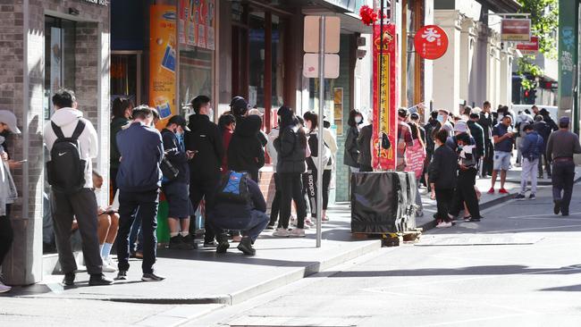 Long queues mounted outside a clinic in Russell St on Monday. Picture: David Crosling