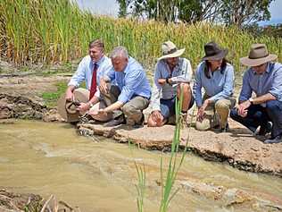 STATE SUPPORT: State Member James Lister (far left) joined the Deputy PM on his tour of the region. The group watch on as water is released from a truck into a Kirra Pines dam. Picture: Matthew Purcell