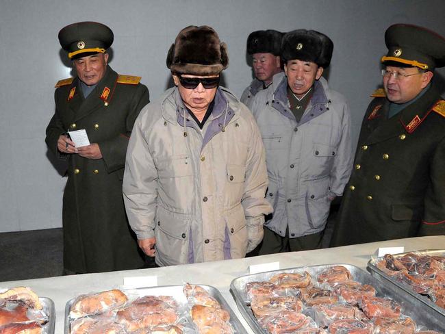 North Korean leader Kim Jong-il inspecting pork products.