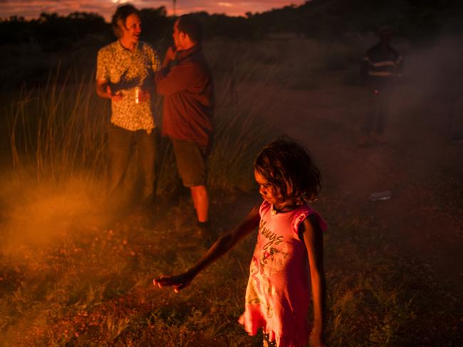 Norm Frank Jupurrurla’s daughter Neetu, 6, by a cooking fire on the block of land where the family’s new home will be built. Picture: Andrew Quilty/Climate Council