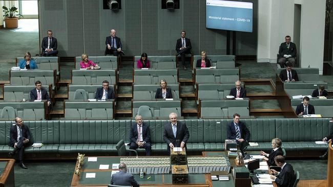 Prime Minister Scott Morrison stands amid a limited number of MP's during a recalled session of Parliament for the Introduction and debate of the coronavirus Economic Response Package (Payments and Benefits) Bill. Picture: Gary Ramage