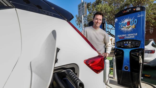 An electric vehicle owner charges his car at a public charging station in Brunswick. Picture: Ian Currie