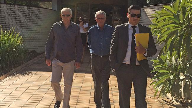 Father Richard St John Cattell in the centre flanked by Nyst Lawyers solicitor Ron Behlau and a supporter at an earlier date.