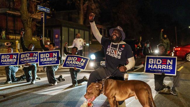 Tyrone Carter, a former NFL player, leads a group of kids who support presidential candidate Joe Biden take a knee and block the road near a polling place in Minneapolis, Minnesota, in 2020. Picture: AFP