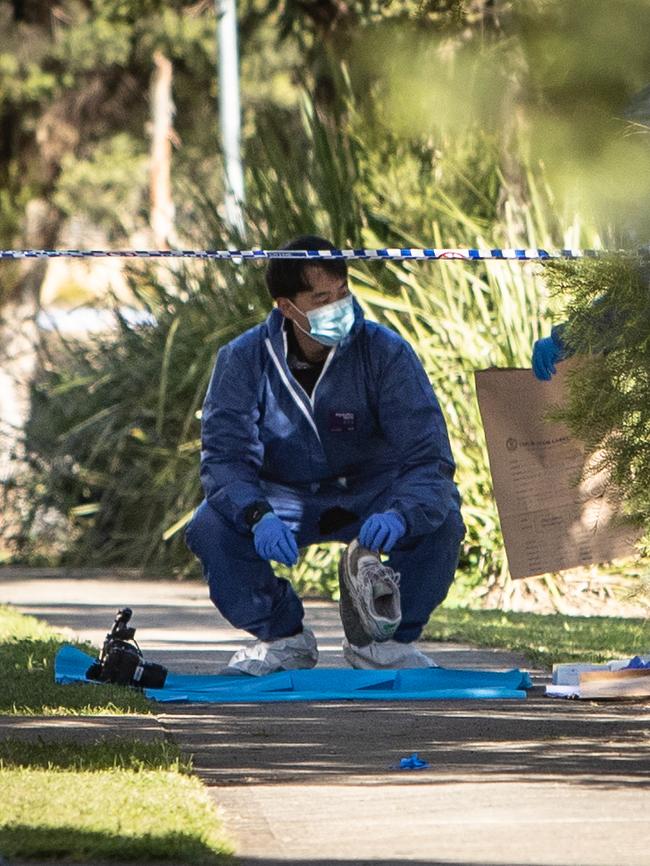 Forensic officers bag a pair of trainers at the scene. Picture: Julian Andrews