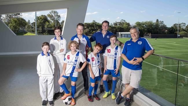 (L-R) Sam Newson-Smith, Harrison Brown, Brodie Strauss, Iain Wood (West Epping Cricket Club Jr President), Alex Brown, Andrew Brown (Epping Football Club committee member), Marcus Brown, & Lex Strauss (Epping Football Club committee member) pose for a photograph inside the new West Epping Park pavilion (AAP IMAGE / Troy Snook)