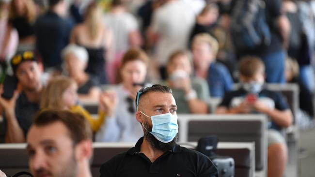 People wait for flights at Adelaide Airport on Monday as new border restrictions come into effect. Picture: David Mariuz