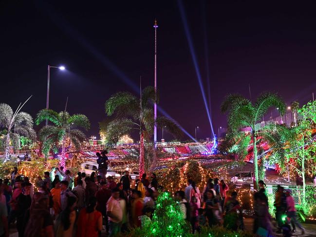 People gather at the sea promenade, lit up during sunset on New Year’s Eve in Mumbai. Picture: AFP