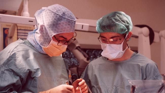 Neurosurgeon Professor Jeffrey Rosenfeld performing a brain surgery operation removing a tumour from a child with assistant surgeon Dr Martin Wood at the Royal Children's Hospital, Melbourne, in 2001. Picture: Peta Philp