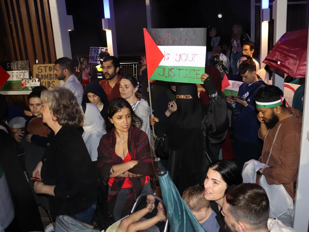 Protesters gathered at Surfers Paradise Esplanade despite torrential rain to call for an immediate ceasefire of bombing in the Gaza Strip. Picture: Amaani Siddeek