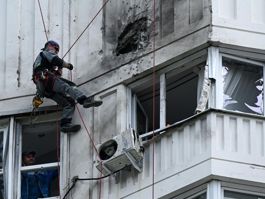 A specialist inspects the damaged facade of a multi-storey apartment building after a drone attack on Moscow. Picture: AFP