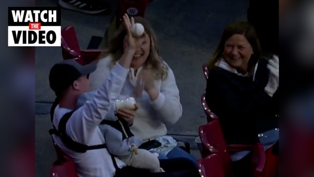 Fan makes incredible catch on foul ball while bottle feeding baby