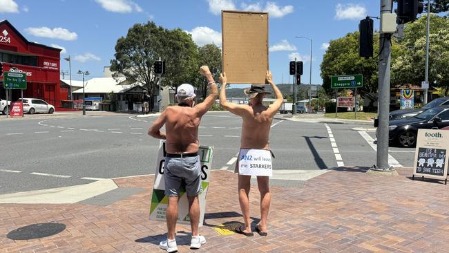 Motorists on Waterworks Rd at Ashgrove got an eyeful when Paul Herman and Peter McQuitty stripped off to protest what they claim is unfair loans. Picture: Contributed