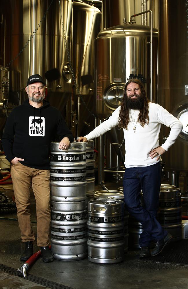 Mr Adamson and Mr McMahon in front of barrels and tanks at their Newtown brewery. Picture: John Appleyard