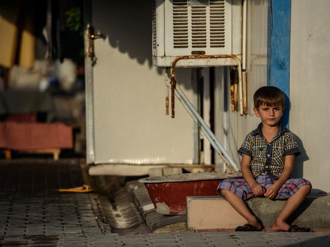 A Syrian child sits at a refugee camp in the Kilis district of Gaziantep, southeastern Turkey, on October 23, 2016. France's foreign minister urged the international community to "do everything" to end the "massacre" in the Syrian city of Aleppo after fighting resumed following a 72-hour truce declared by Damascus ally Russia. / AFP PHOTO / OZAN KOSE