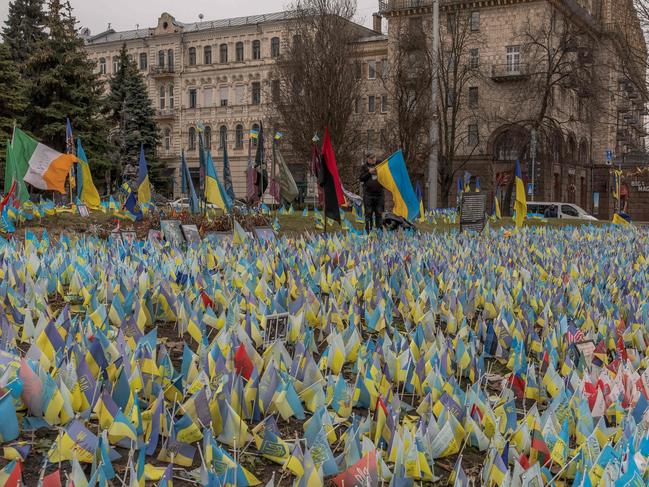 A man sets a Ukrainian flag next to flags bearing symbols and colours of Ukraine to commemorate fallen Ukrainian army soldiers at Independence Square in Kyiv on the second anniversary of Russia's invasion of Ukraine. Picture: AFP