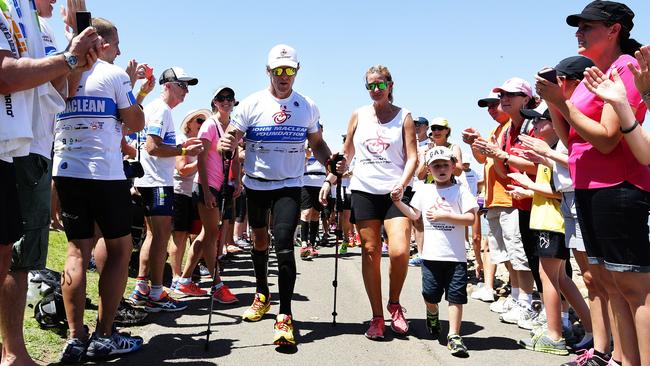 Wheelchair athlete John Maclean finishes competing in the Nepean Triathlon as an able-bodied athlete with his son Jack and wife Amanda at Penrith in 2014.