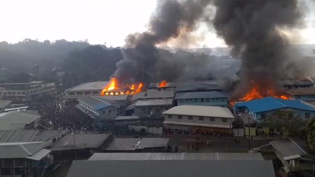 Large crowds near burning buildings in the Chinatown district of the Solomon Islands’ capital, Honiara, on Thursday. Picture: Twitter