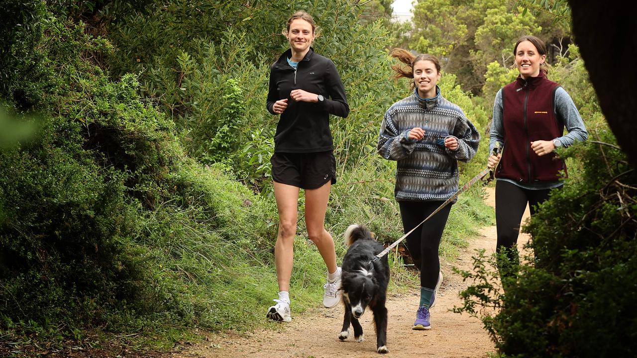 Torquay Run Club women’s and LQBTQIA+ night jog members Emily Cerini, left, Katelyn Dooley and Eliza Nolan with Harper the dog. Picture: Alison Wynd