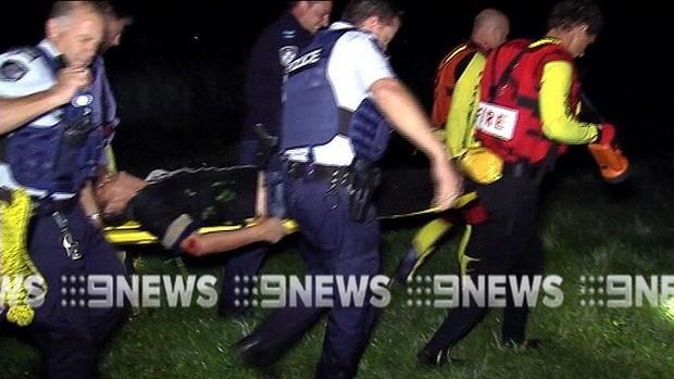 Police and emergency services crews carry the injured man. Picture: Nine News