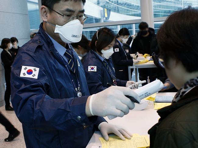 A South Korean quarantine officer checks passengers from a flight from Wuhan. Picture: Korea Centers for Disease Control and Prevention/Getty