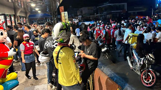 People gather along a street after evacuating from inside buildings after a 7.6 earthquake struck Butuan City. Picture: Ted Aljibe / AFP