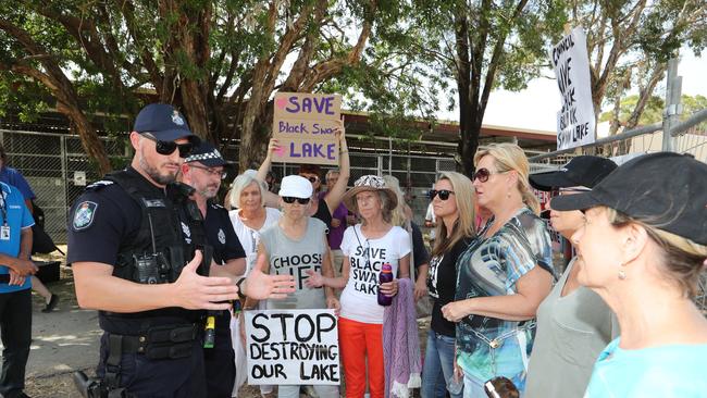 Black Swan Lake protest at Bundall goes to another level, with protesters chaining themselves to the fence and then getting themselves arrested after running onto the worksite and stopping the trucks. Police inform protesters of the situation. Picture Glenn Hampson