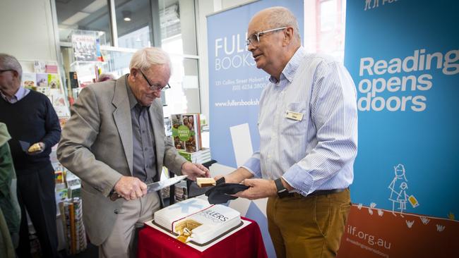 Fullers bookstore owner Clive Tilsley (right) hands out cake to celebrate the shop's 100 year anniversary. Picture: LUKE BOWDEN