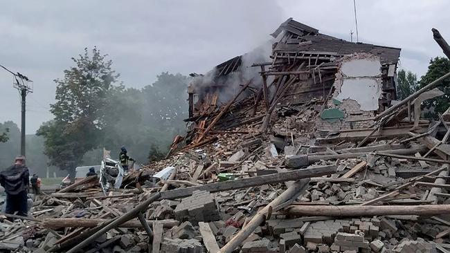 Firefighters removing rubble from a destroyed building after a missile strike in the city of Nikopol, likely launched from the grounds of the nuclear power plant. . (Photo by AFP) /