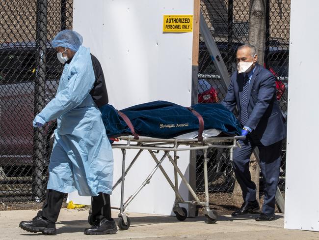 A funeral director and a medical centre employee transport a body in New York. Picture: AP,