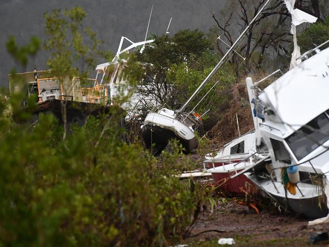 Boats are seen smashed against a bank at Shute Harbour, Airlie Beach, Wednesday, March 29, 2017. Cyclone Debbie has hit Queensland's far north coast yesterday as a category 4 cyclone, causing wide spread damage. Picture: AAP Image/Dan Peled