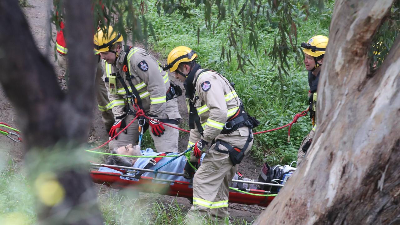 Rescue crews remove the man from the banks of the Yarra in Melbourne’s east on Wednesday morning. Picture: David Crosling