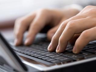 Close-up of male fingers typing a business document on the black laptop