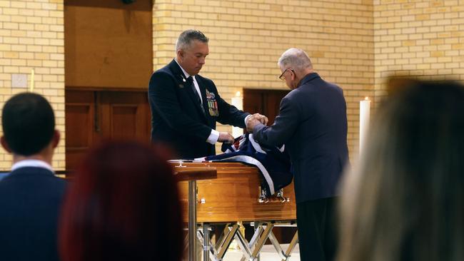 Cairns RSL sub branch president Nathan Shingles places an Australian flag over the coffin of Kevin Byrne at the former Cairns mayor's funeral service, held at St Monica's Cathedral. Picture: Brendan Radke