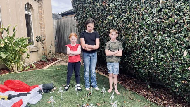 Alyssa, Ashleigh and Nate Mackie in front of their family's ruined Christmas display.