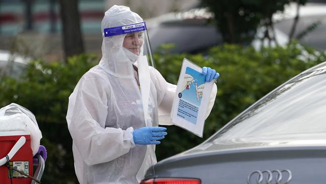 Pharmacist Mary Reamer holds up instructions at a self-collection COVID-19 testing site in Houston. COVID-19 cases continue to surge across Texas. Picture: AP