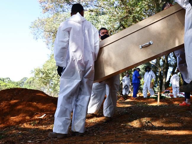 Cemetery workers in protective suits prepare to carry the coffin of a COVID-19 victim to be buried in Sao Paulo, Brazil. Picture: Getty Images