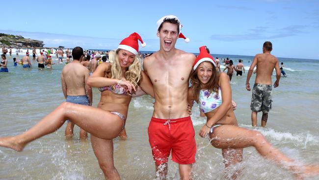 British tourists Georgia Dymoke, George Carter and Phoebe Darwin enjoy a splash at Bondi Beach on Christmas Day last year. Picture: Chris Pavlich