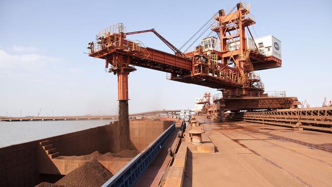 A barge is loaded with iron ore at a storage centre in Shanghai. China is the world’s biggest importer of the resource. Picture: Bloomberg