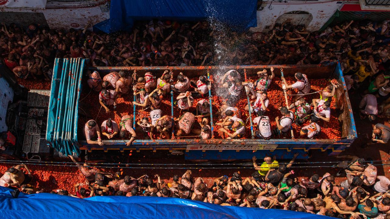 One of six trucks full of tomatoes is seen arriving at the town square. Teams on board distributed the 130-tonne load to the waiting crowd. Picture: Zowy Voeten/Getty Images