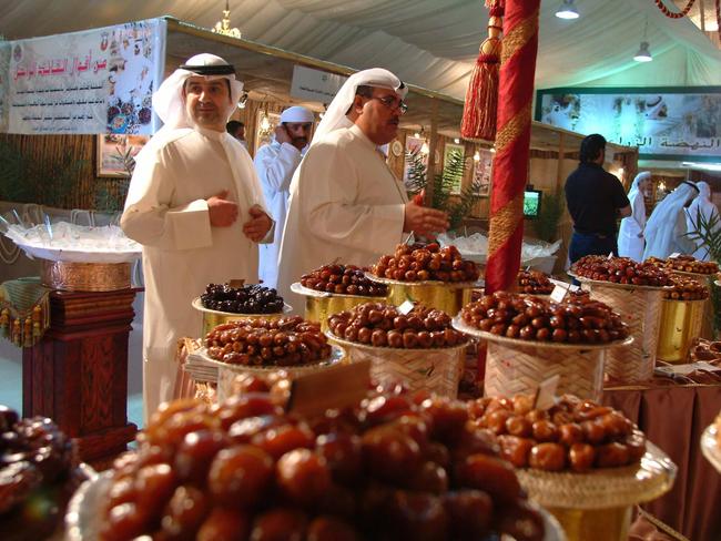 Tasting and selecting dates in a souk (market) in Abu Dhabi, United Arab emirates (UAE). Pic Abu Dhabi Tourism Authority.